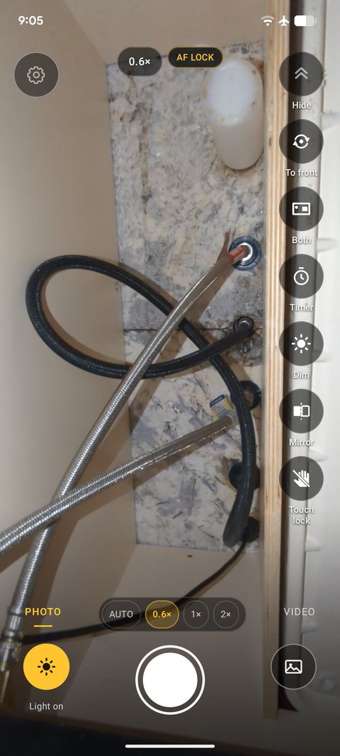 A real InspectCam screenshot under a kitchen sink: the supply hoses and shut-off valves lit by the phone's light.